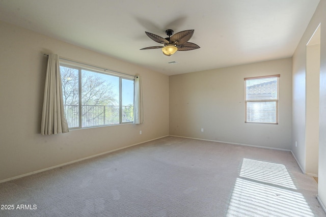 spare room featuring light carpet and ceiling fan