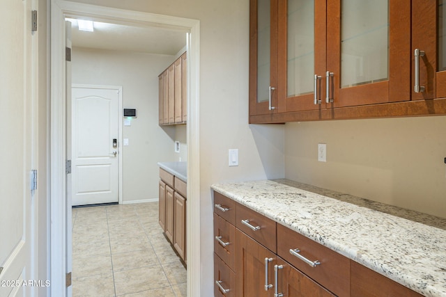 kitchen featuring light tile patterned flooring and light stone countertops