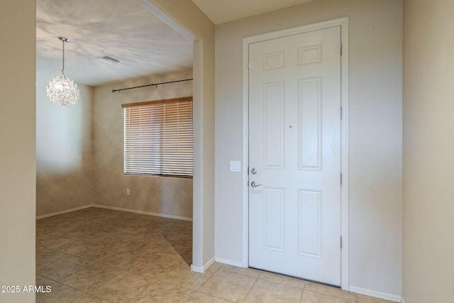 foyer entrance with a chandelier and light tile patterned flooring