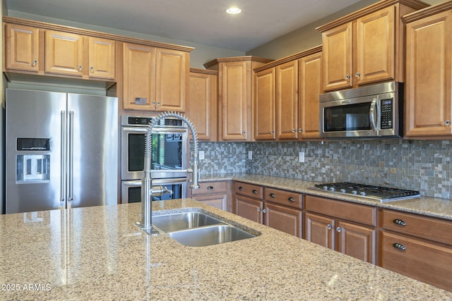 kitchen with tasteful backsplash, light stone counters, and appliances with stainless steel finishes