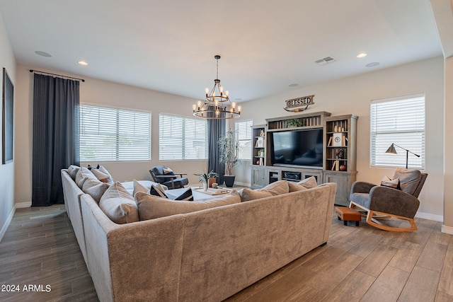 living room with plenty of natural light, an inviting chandelier, and hardwood / wood-style flooring