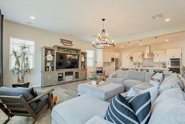 living room with a notable chandelier and light wood-type flooring