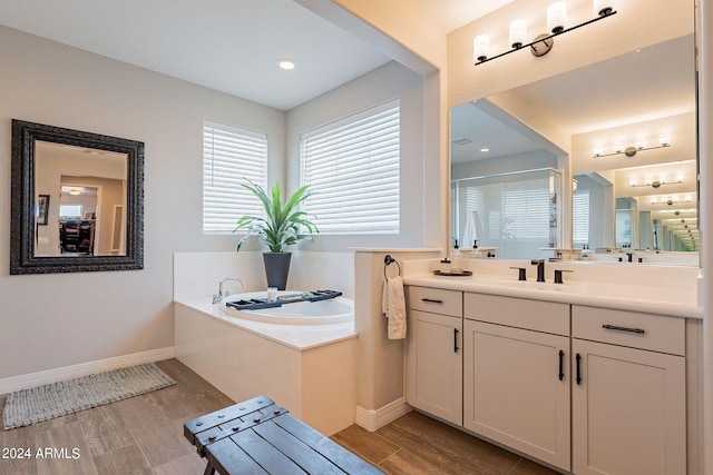 bathroom with hardwood / wood-style floors, vanity, and a bath