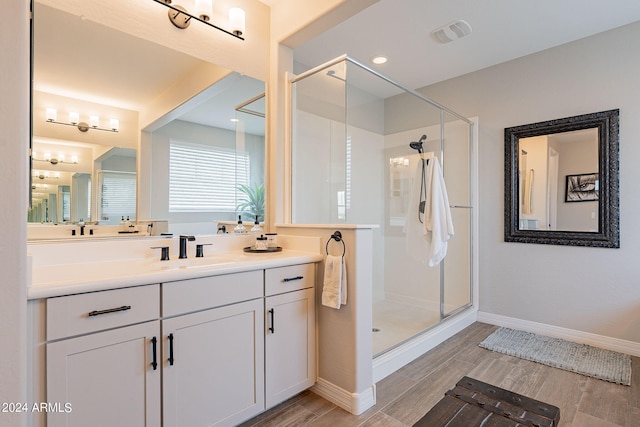 bathroom featuring a shower with door, vanity, and wood-type flooring