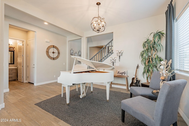 miscellaneous room with light hardwood / wood-style floors and a notable chandelier