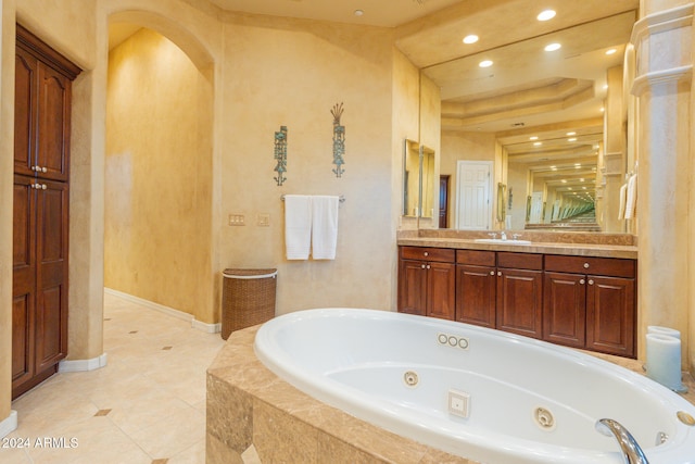 bathroom featuring vanity, a relaxing tiled tub, and tile patterned flooring