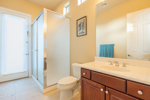 bathroom with vanity, toilet, tile patterned floors, and a shower with shower door