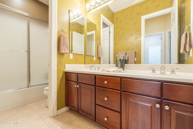 full bathroom with vanity, toilet, tile patterned floors, and bath / shower combo with glass door