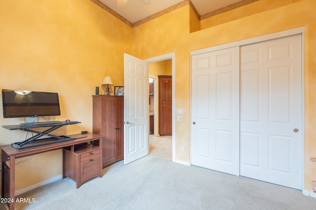 carpeted home office featuring ornamental molding and a towering ceiling