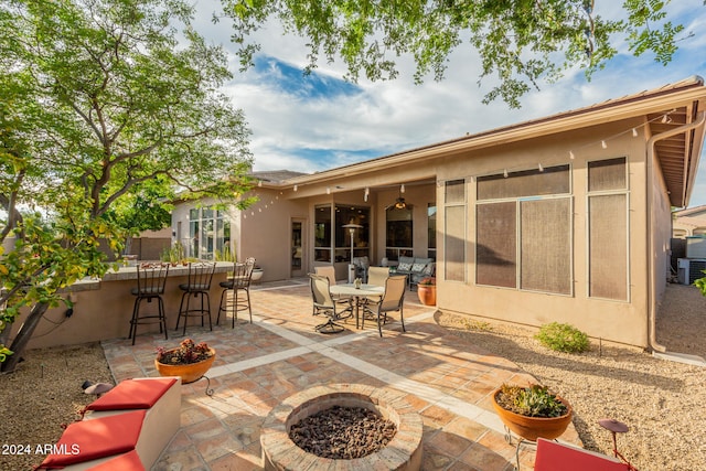 view of patio / terrace with an outdoor fire pit and exterior bar