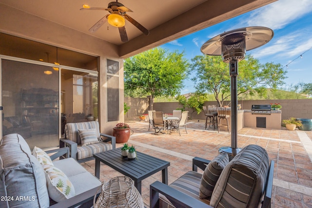 view of patio / terrace featuring an outdoor living space, exterior kitchen, grilling area, and ceiling fan