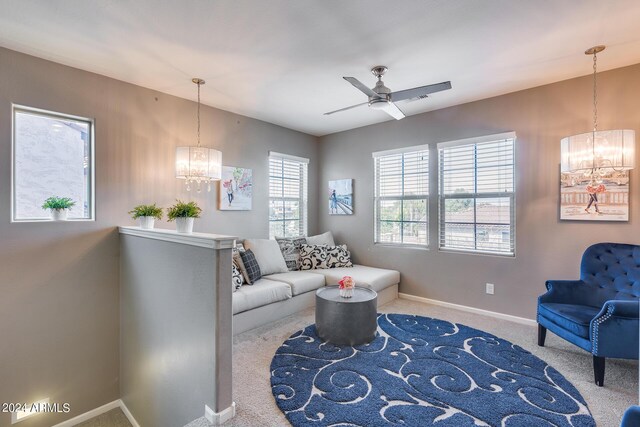 living room with ceiling fan with notable chandelier and carpet floors