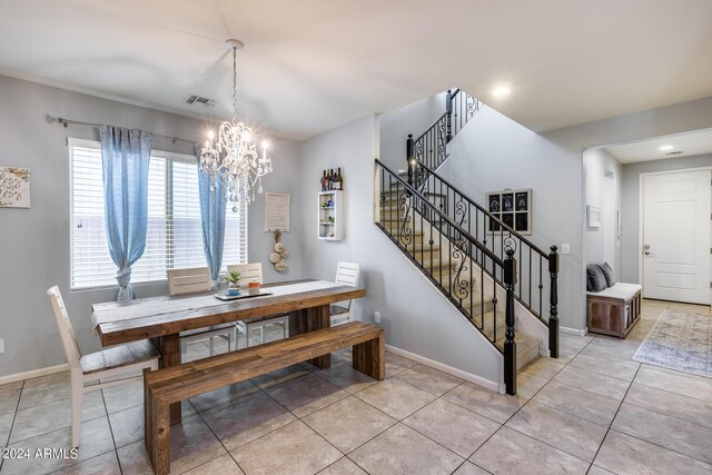 tiled dining room with a chandelier