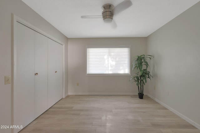 unfurnished bedroom with ceiling fan, a closet, and light hardwood / wood-style flooring