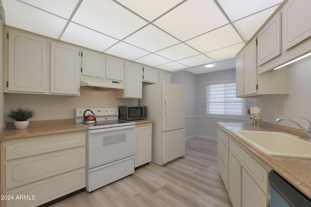 kitchen with cream cabinets, sink, stainless steel appliances, and light wood-type flooring