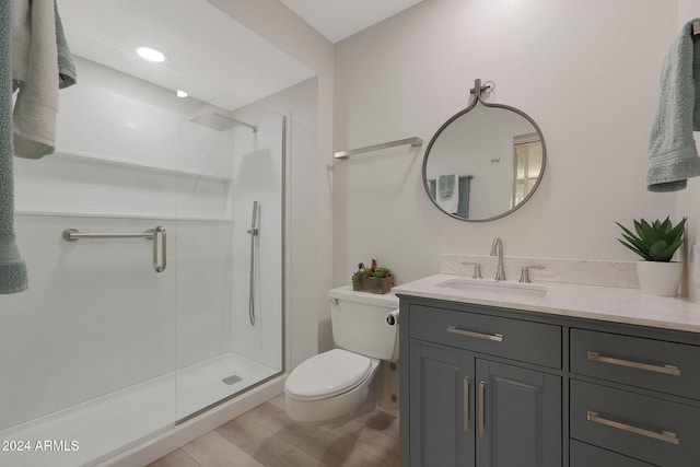 bathroom featuring vanity, an enclosed shower, and toilet