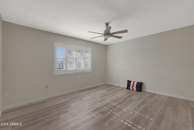 empty room with ceiling fan and light hardwood / wood-style flooring