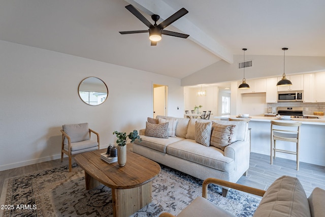 living room featuring ceiling fan with notable chandelier, vaulted ceiling with beams, and light wood-type flooring