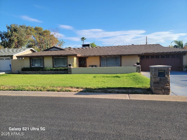 ranch-style home featuring a garage and a front lawn