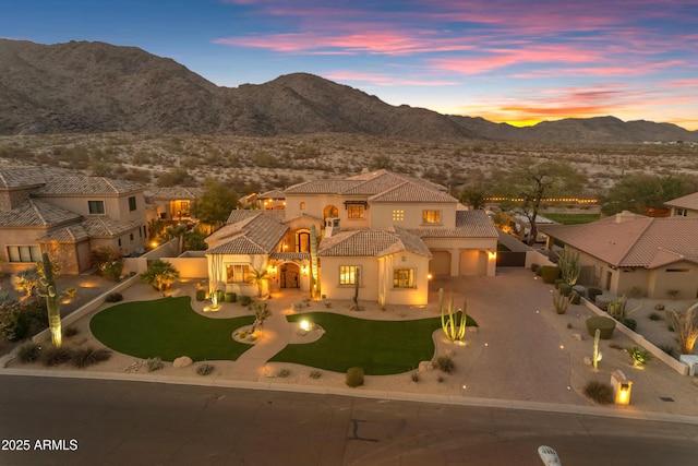 view of front of home with a tiled roof, a balcony, a mountain view, and curved driveway