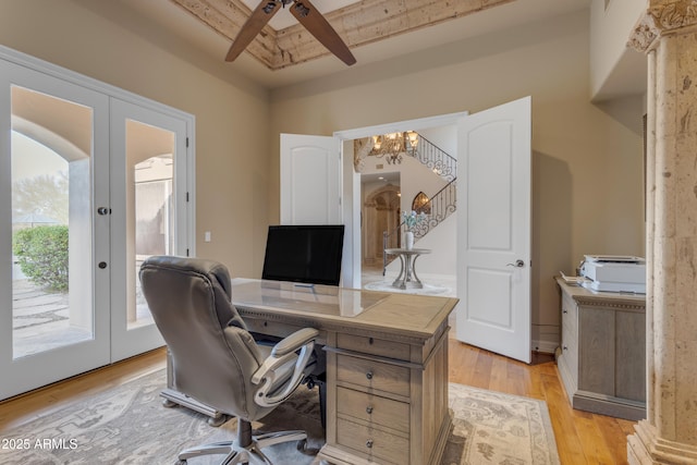 home office with french doors, arched walkways, a notable chandelier, and light wood finished floors