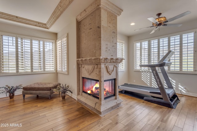 exercise room with wood finished floors, a wealth of natural light, and a premium fireplace