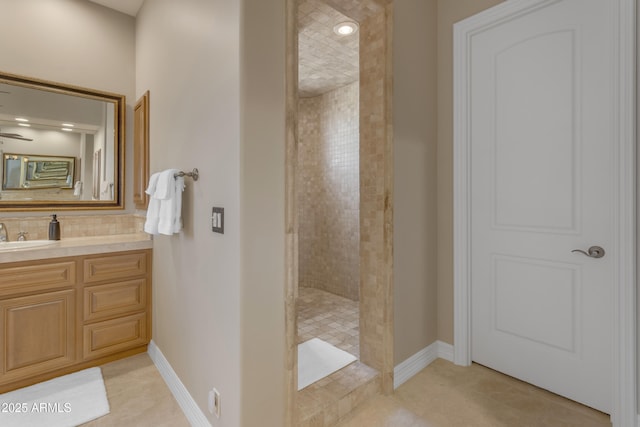 bathroom featuring baseboards, tiled shower, tasteful backsplash, and vanity