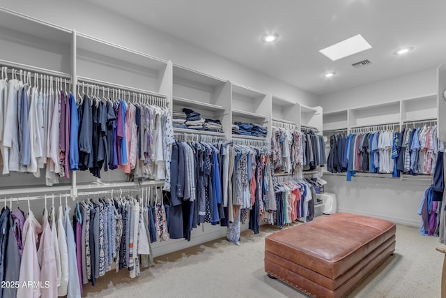 walk in closet with visible vents, a skylight, and carpet