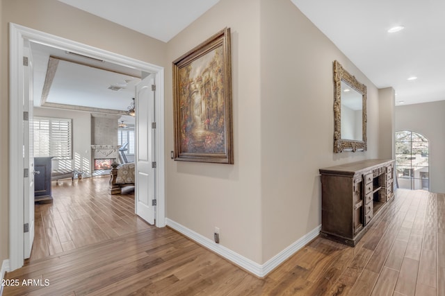 hallway with recessed lighting, light wood-type flooring, baseboards, and visible vents