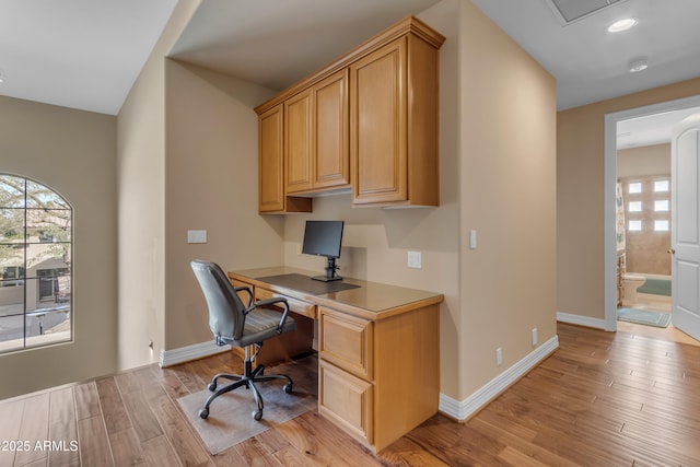 office area with baseboards, a healthy amount of sunlight, light wood-style flooring, and built in study area