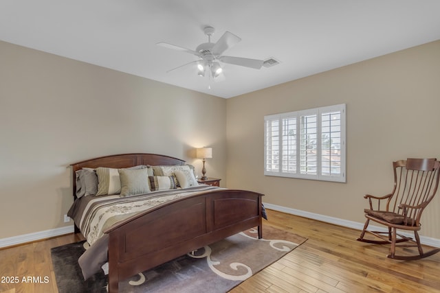 bedroom featuring visible vents, baseboards, and wood finished floors