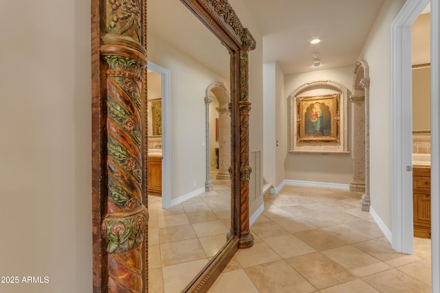 corridor featuring recessed lighting, baseboards, and light tile patterned floors