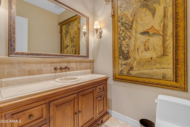 half bath with toilet, tasteful backsplash, tile patterned flooring, baseboards, and vanity