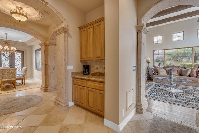 bar with decorative columns, arched walkways, backsplash, and visible vents