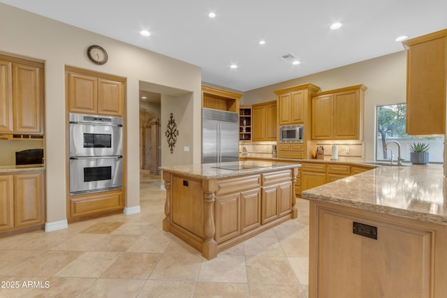 kitchen with tasteful backsplash, visible vents, built in appliances, light stone counters, and a sink