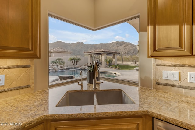 kitchen with decorative backsplash, a mountain view, a wealth of natural light, and a sink