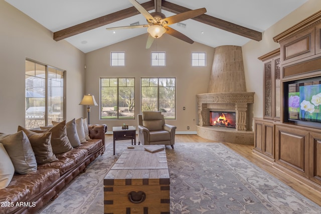 living area featuring beam ceiling, light wood-style floors, a high end fireplace, and high vaulted ceiling