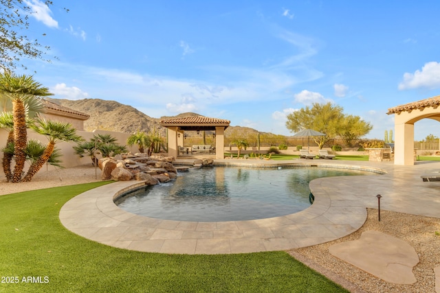 view of pool featuring a fenced in pool, a fenced backyard, a gazebo, a patio area, and a mountain view