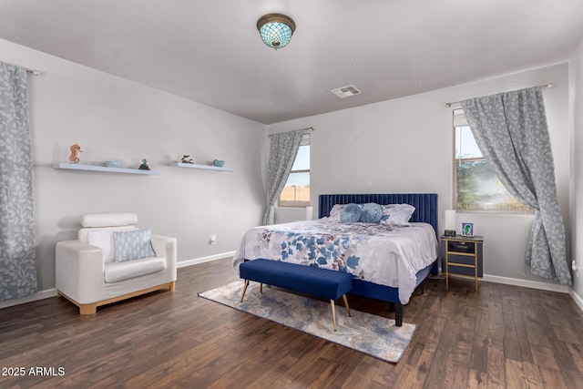 bedroom featuring baseboards, visible vents, and wood finished floors