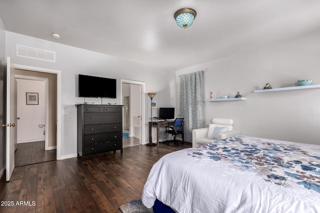bedroom with connected bathroom, visible vents, and wood finished floors