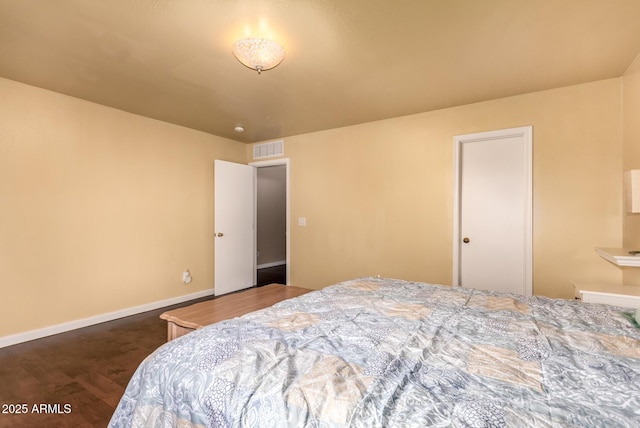 bedroom featuring baseboards, visible vents, and wood finished floors