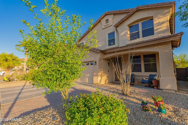 traditional-style home featuring a garage and stucco siding