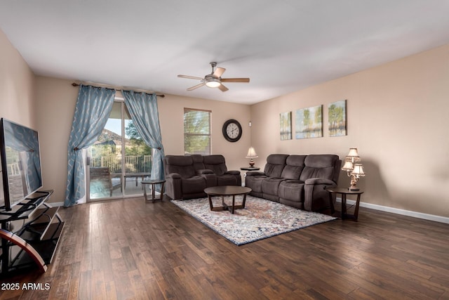 living room with baseboards, a ceiling fan, and dark wood finished floors