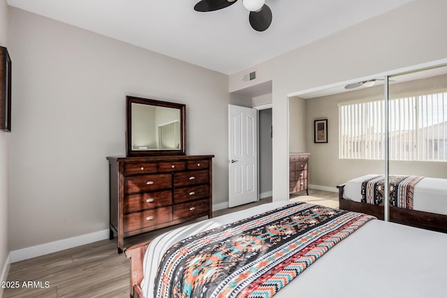 bedroom with ceiling fan, light hardwood / wood-style floors, and a closet