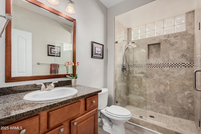 bathroom with an enclosed shower, vanity, and toilet