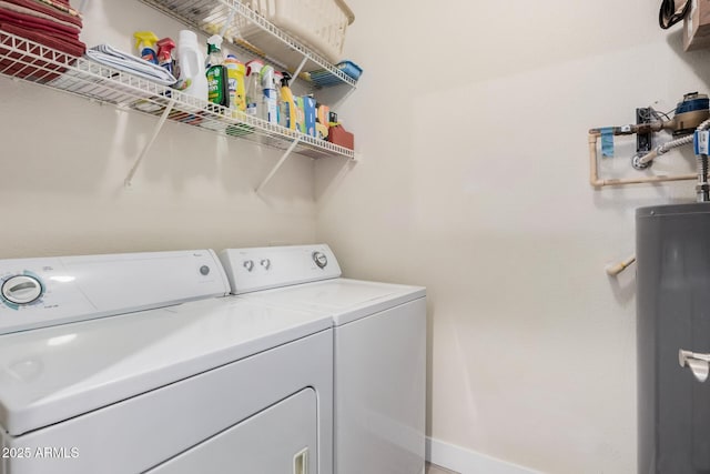 laundry room with water heater and washing machine and clothes dryer