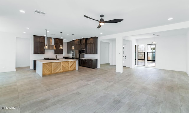 812 E Summerside Rd, Phoenix, AZ 85042 - kitchen with wall chimney range hood, open floor plan, light countertops, dark brown cabinets, and an island with sink