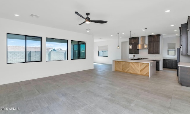 812 E Summerside Rd, Phoenix, AZ 85042 - kitchen featuring wall chimney range hood, open floor plan, light countertops, a ceiling fan, and a kitchen island with sink