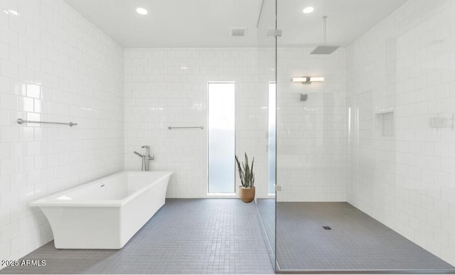 812 E Summerside Rd, Phoenix, AZ 85042 - bathroom with tile patterned floors, a freestanding bath, a tile shower, tile walls, and recessed lighting