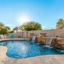 view of swimming pool with fence, a fenced in pool, and a jacuzzi